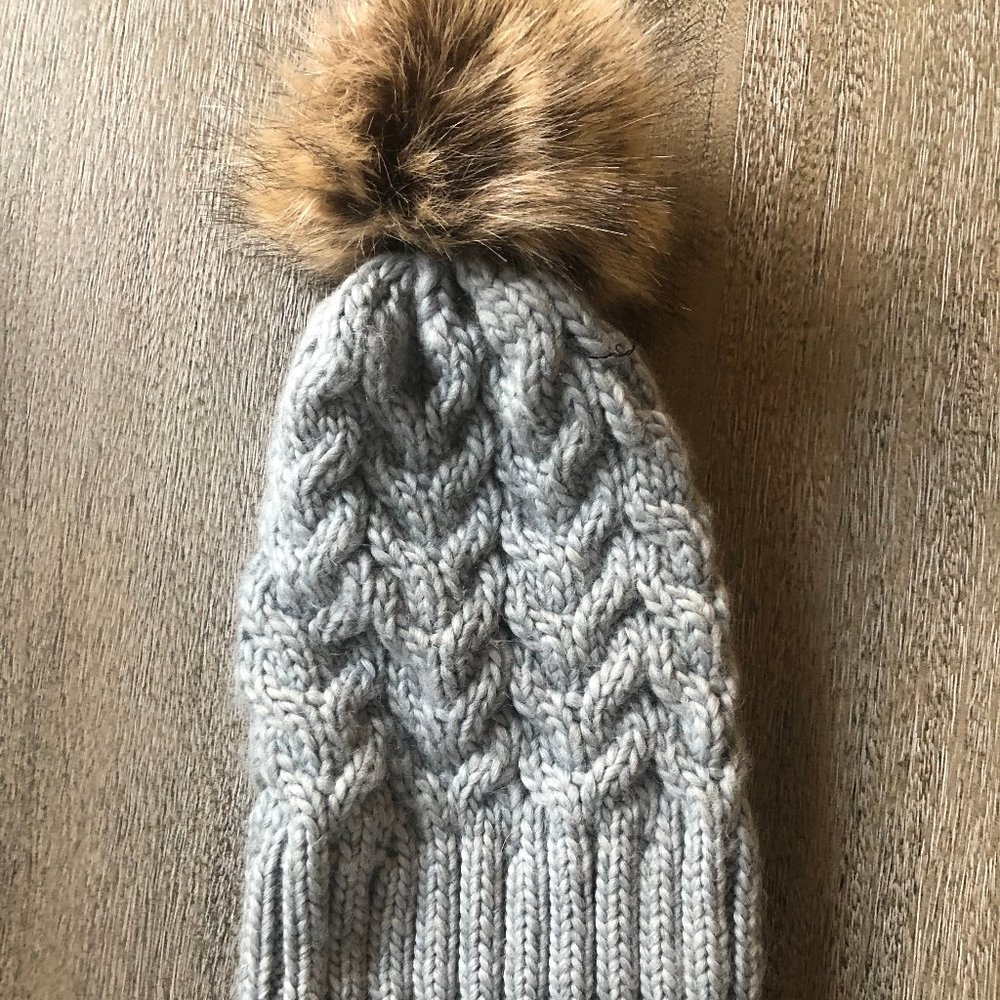 grey knit winter hat with pom pom